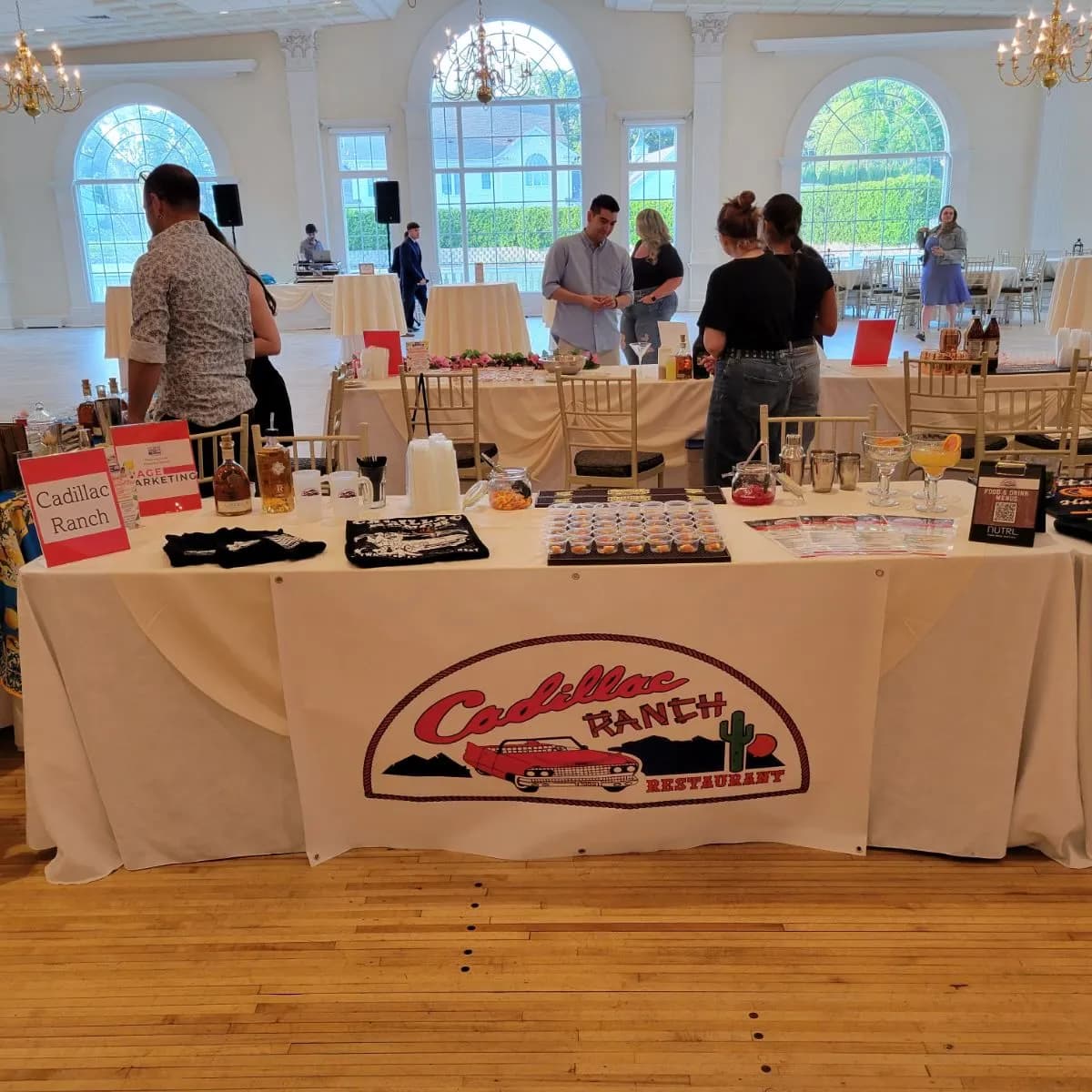 The Cadillac Ranch table at a community tasting event, with merch and the brand banner