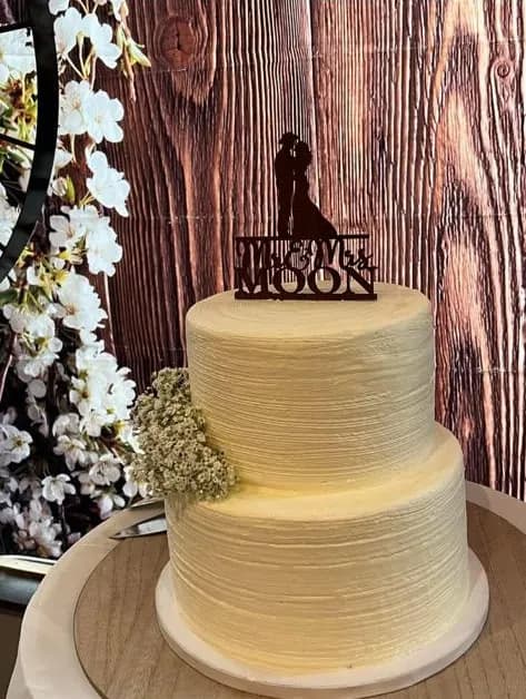A two-tier 'Mr & Mrs Moon' wedding cake with a silhouette topper at Cadillac Ranch