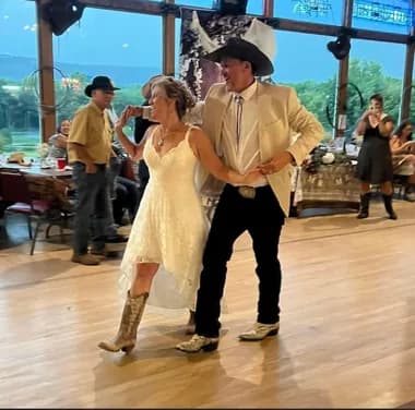 Newlyweds dancing by the venue's large windows